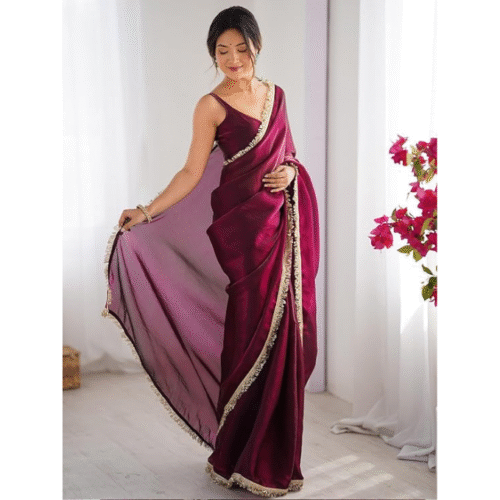 Side pose highlighting drape and border design of satin magenta saree for women